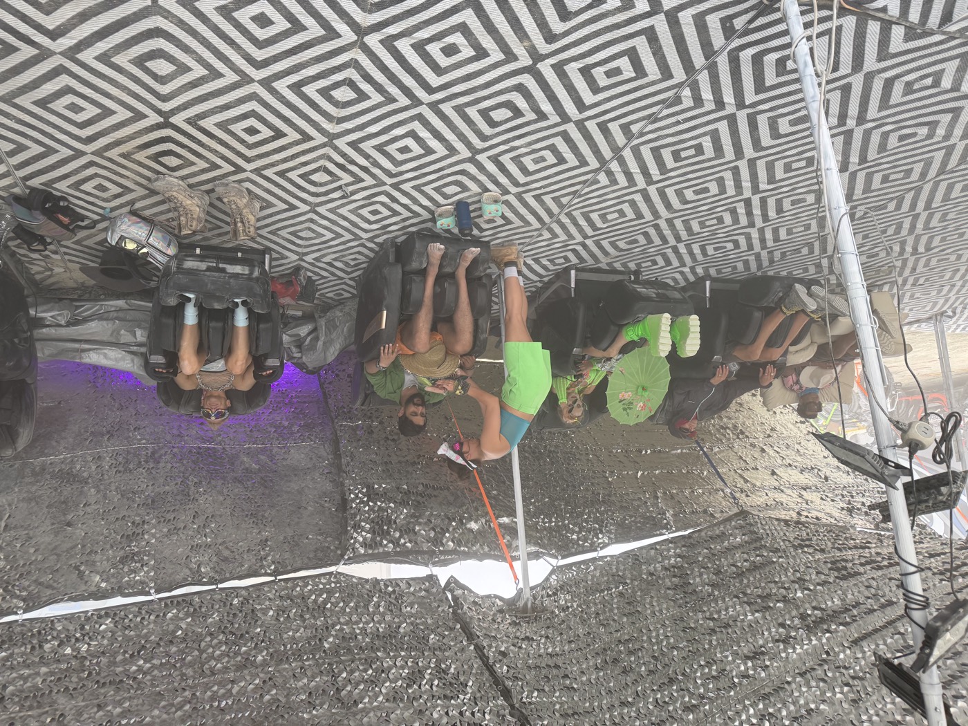 Campers relaxing in massage chairs under shade netting